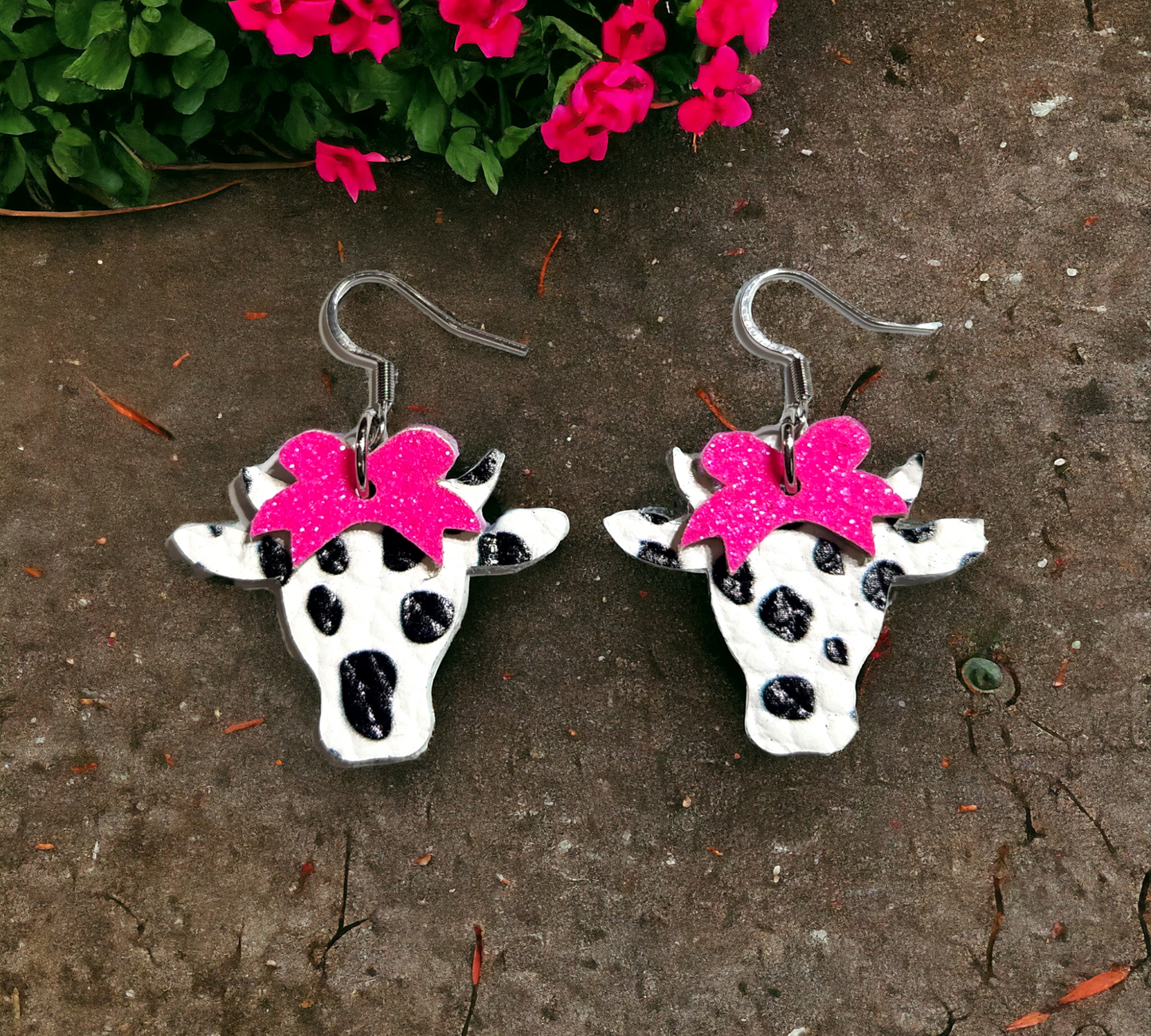 Black and white spotted cows with pink bows